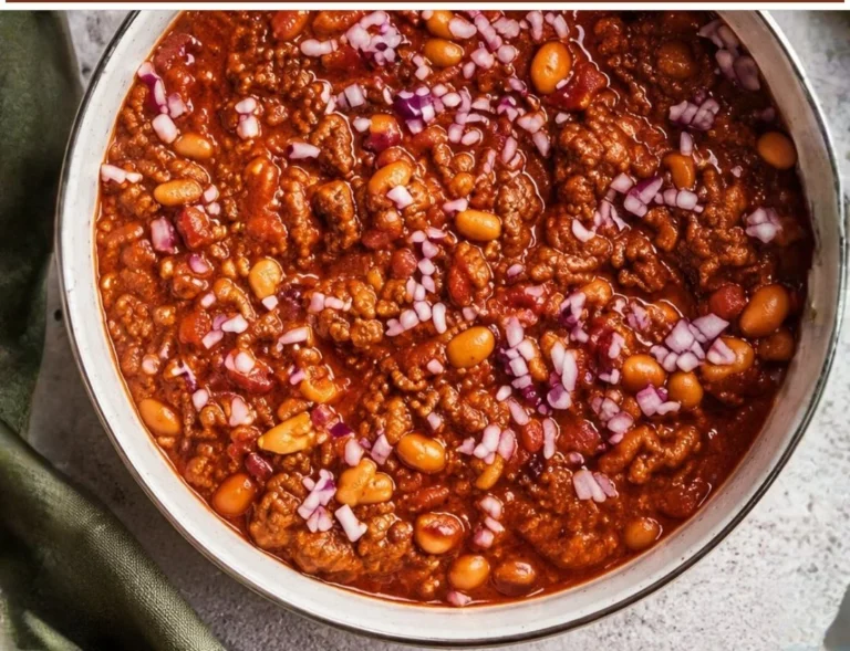 Hearty beef chili in a bowl garnished with fresh herbs and spices