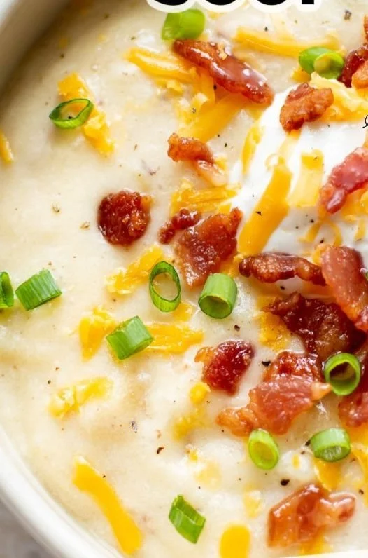 Bowl of creamy loaded potato soup topped with green onions and bacon