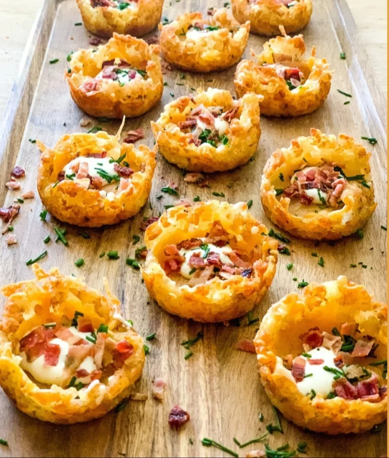 Loaded tater tot appetizers topped with cheese and toppings on a platter.