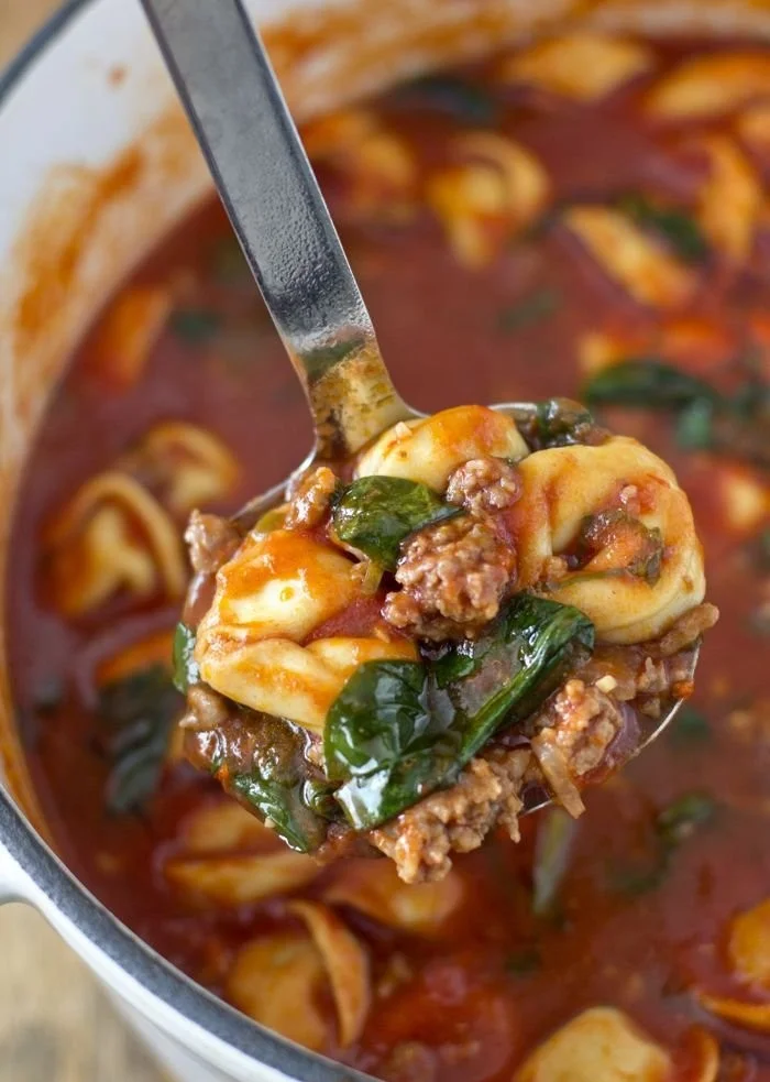 Bowl of Tortellini Soup with Italian Sausage and Spinach garnished with parsley