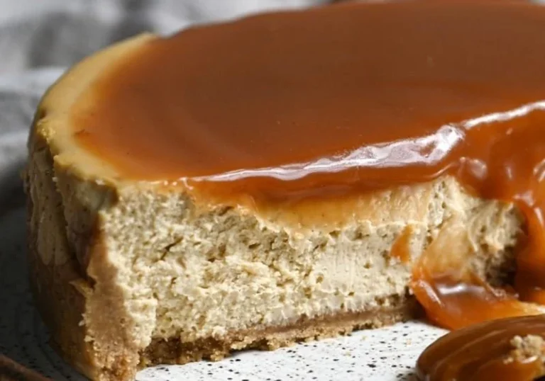 Slice of apple cider cheesecake topped with caramel and apple slices