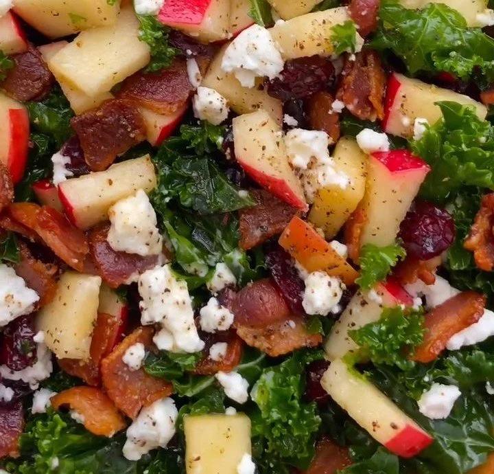 Apple Cranberry Kale Salad with crispy bacon and vibrant ingredients in a bowl.