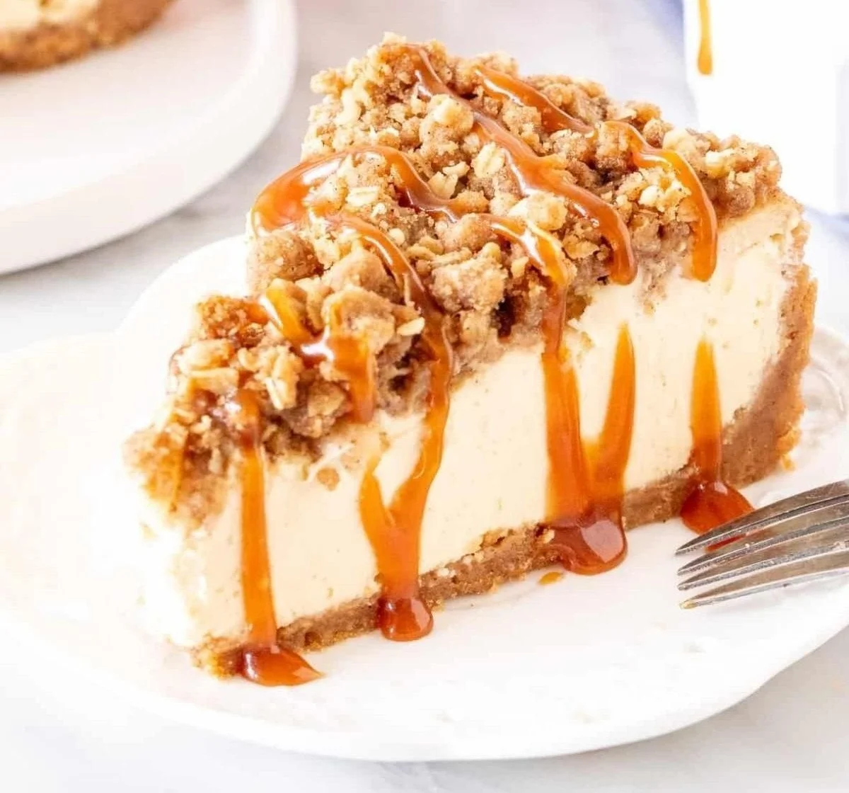 Delicious Apple Crisp Cheesecake topped with crumble and fresh apples