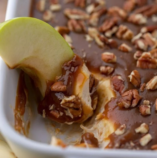 Delicious caramel apple cheesecake dip served with apple slices and graham crackers
