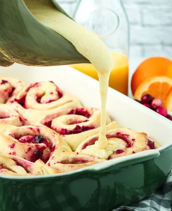 Freshly baked cranberry orange rolls on a wooden table