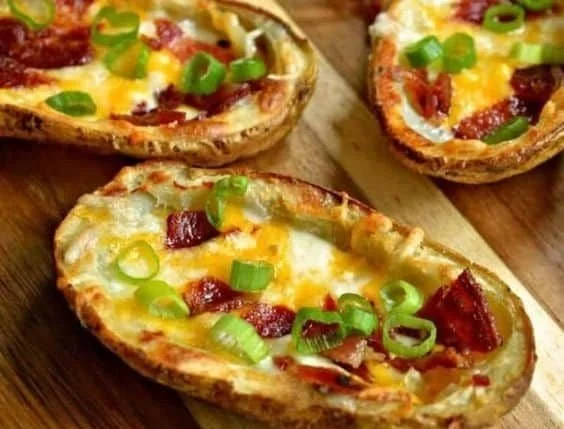 Crispy baked potato skins topped with bacon and green onions on a plate
