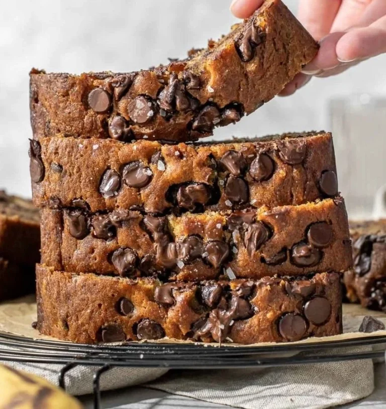 Moist chocolate chip banana bread slices on a wooden cutting board