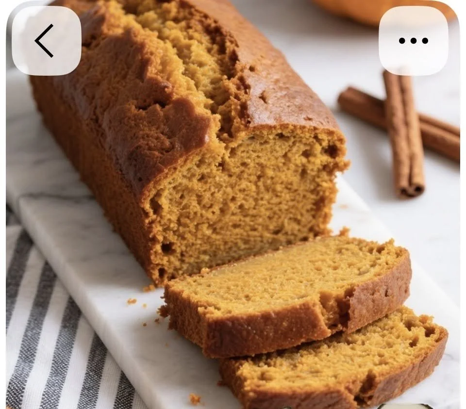 Sliced nut-free pumpkin bread on a wooden table with autumn decorations.