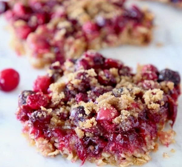 Freshly baked oatmeal cranberry bars on a wooden board