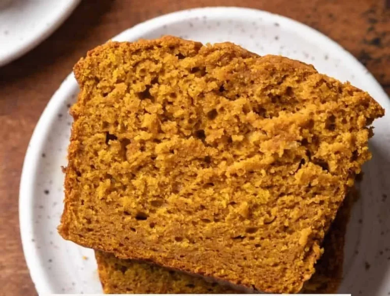 Slice of moist pumpkin bread with sour cream on a plate