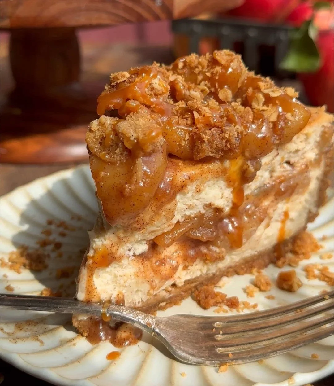 Slice of salted caramel apple pie cheesecake topped with caramel drizzle
