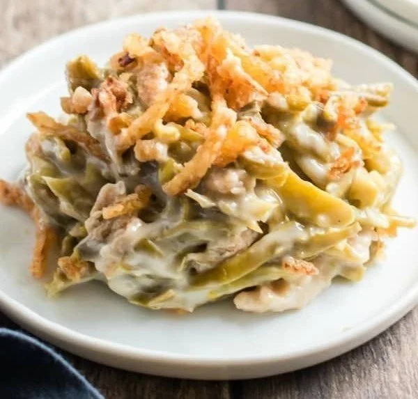 Delicious green bean casserole topped with crispy onions, perfect for Thanksgiving dinner.
